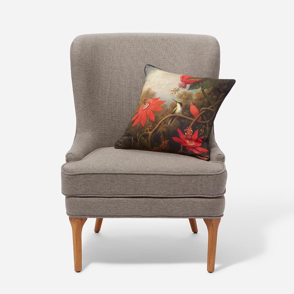 an upholostered chair accented with an art-inspired pillow