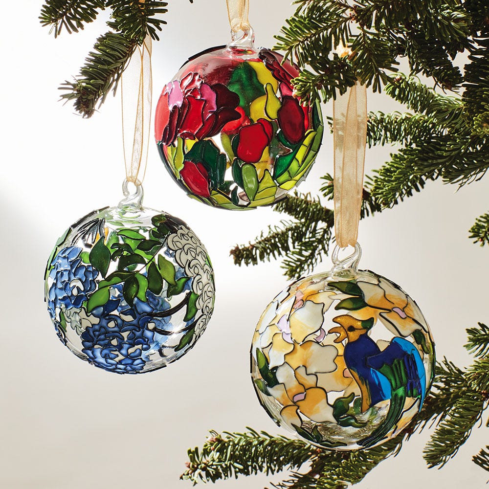 three glass ornaments hanging on a Christmas tree