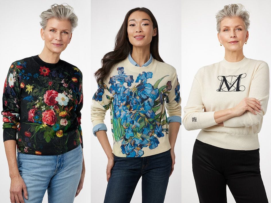 Three women wearing multicolor sweaters with artwork